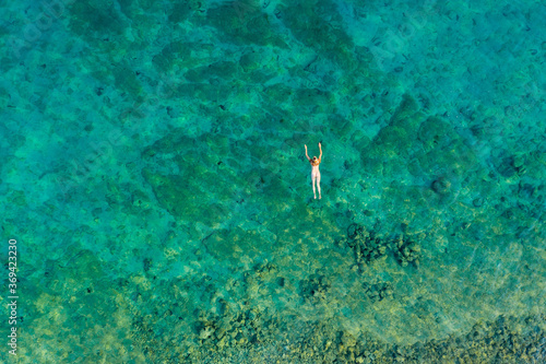 Aerial view of a naked girl swimming in sea