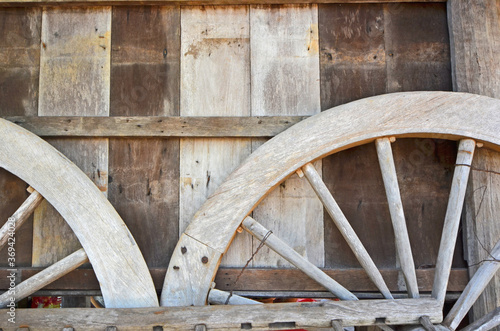Parts of on wagon wheels on wooden wall background
