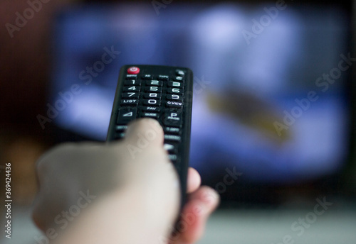 A hand holding a remote control, close up