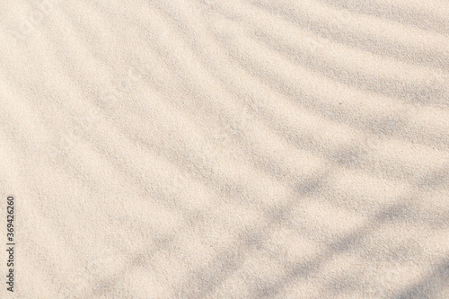 Shadows and patterns on the sand of dune. Sandy beach for the background. Sand texture. Background, sand, light, beige, wave, reflect, shadow, summer.