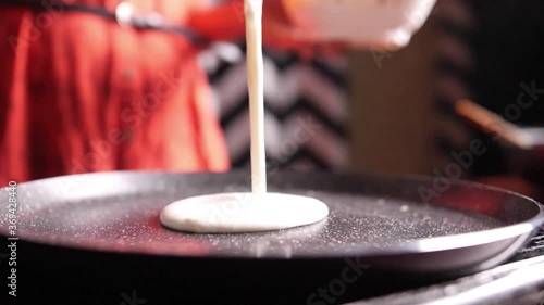 Closeup slow motion view of steaming hot 'Dosa' on a nonstick pan. Dosa is the Indian version of pancake made with rice flour dough
