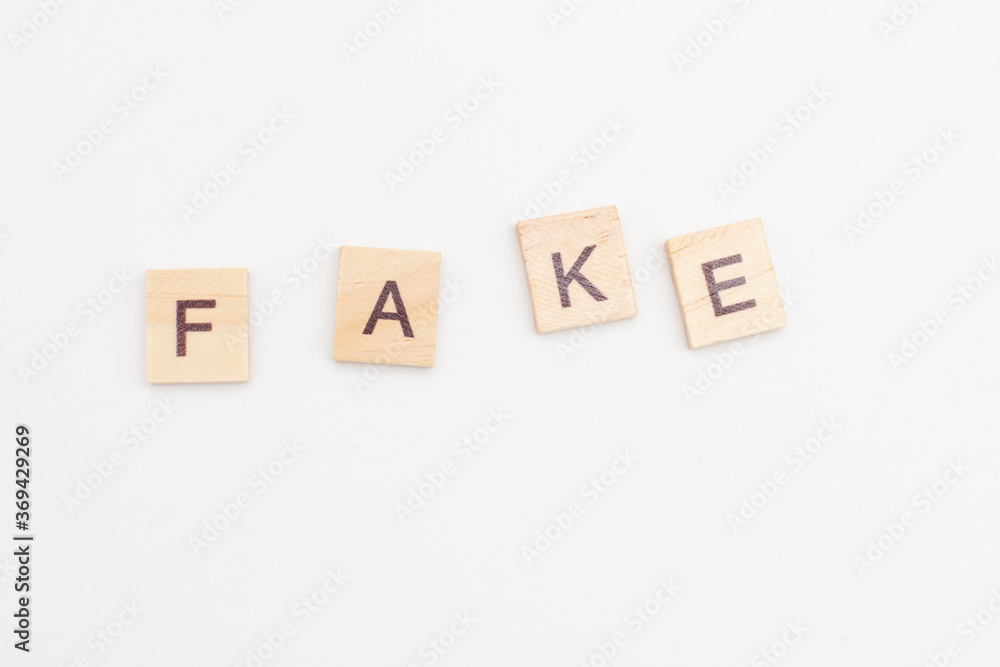 FAKE word made by wooden blocks. News concept FAKE word made by wooden blocks. News concept