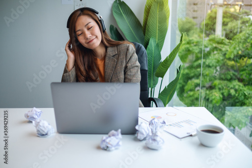 A beautiful young businesswoman enjoy listening to music to relieve stressed at work