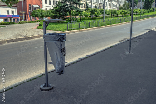 Kharkiv, Ukraine - July 20, 2020: Street trash can in Kharkov on Bursatskyi descent. One iron litter bin with gray plastic bags close-up outdoors photo