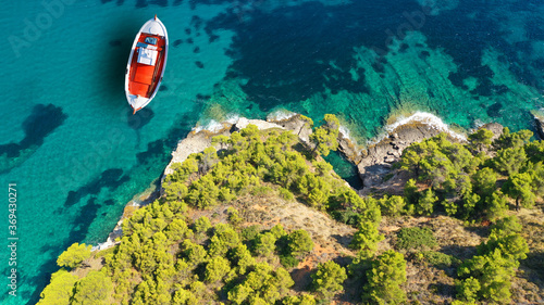 Aerial drone top down photo of traditional fishing boat anchored near small picturesque port of Agnontas, Skopelos, Sporades, Greece © aerial-drone