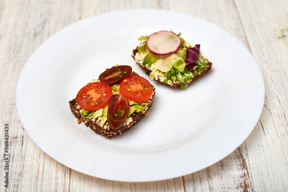 Slice of cereal bread with cream cheese, avocado and vegetables. Vegetarian sandwich. Slice of cereal bread with cream cheese, avocado and vegetables. Vegetarian sandwich.