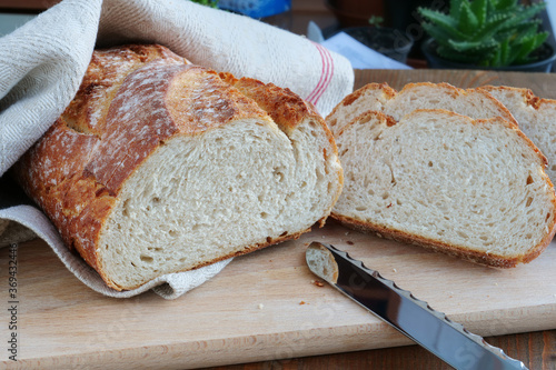 Freshly baked artisan potato bread sliced on wooden board