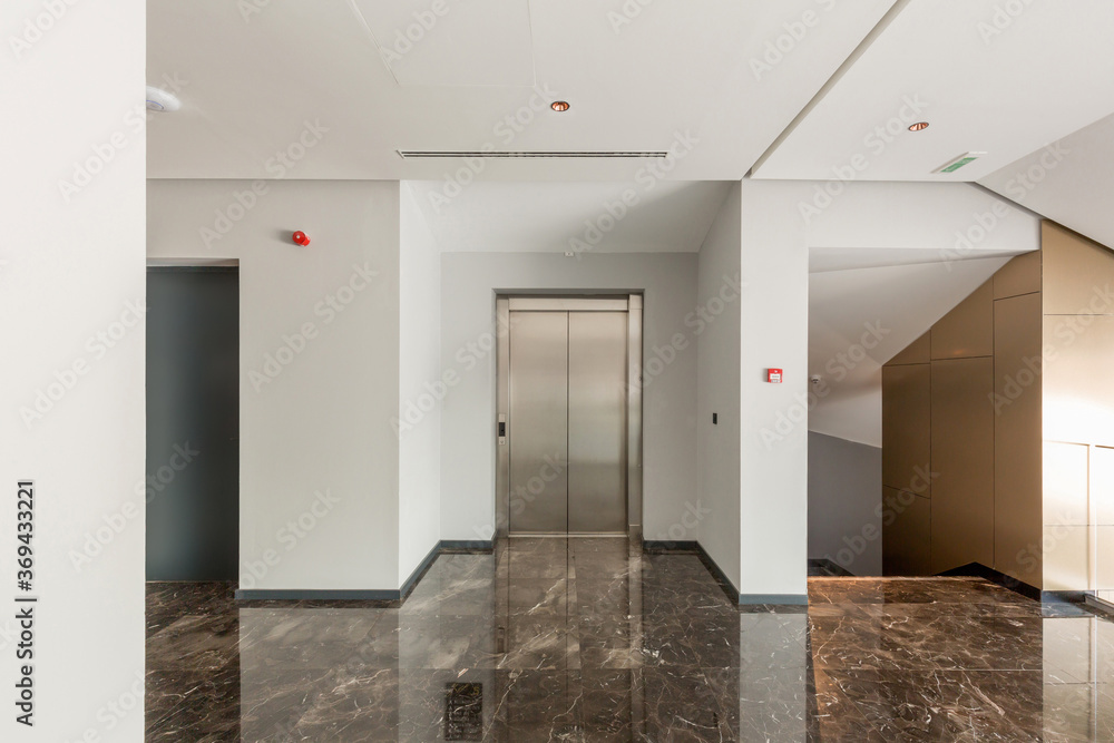 Obraz premium Hotel lobby with shiny marble floor and elevator door