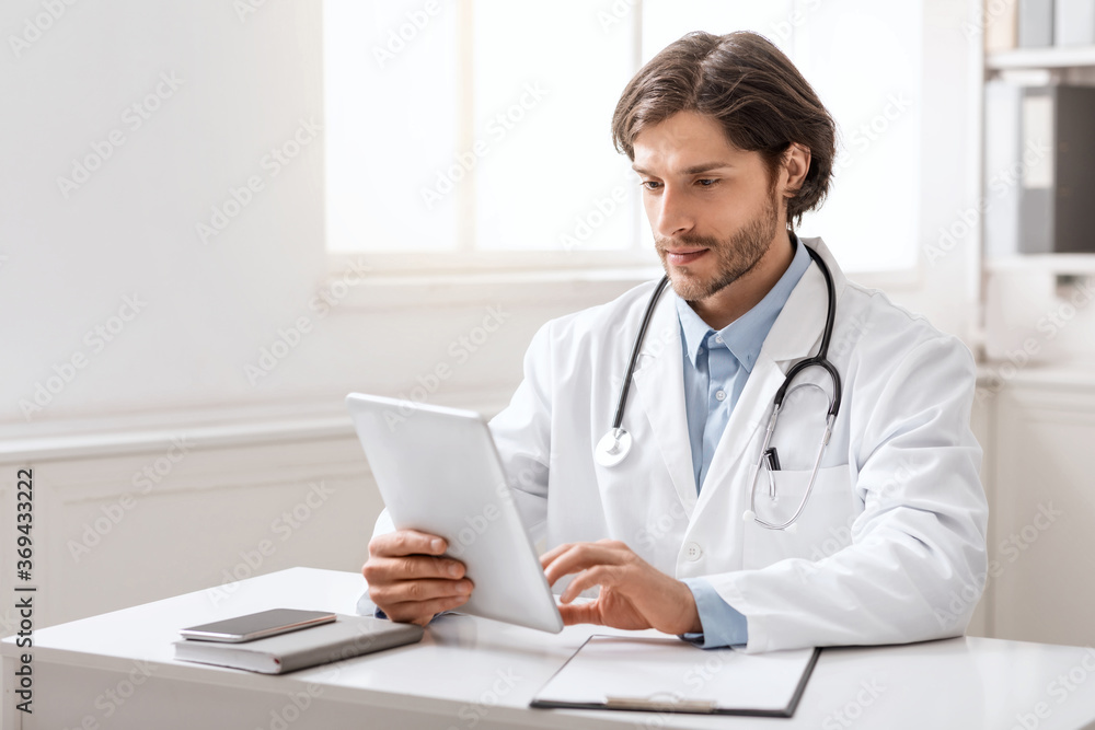 Young doctor using digital tablet for work in office Young doctor using digital tablet for work in office