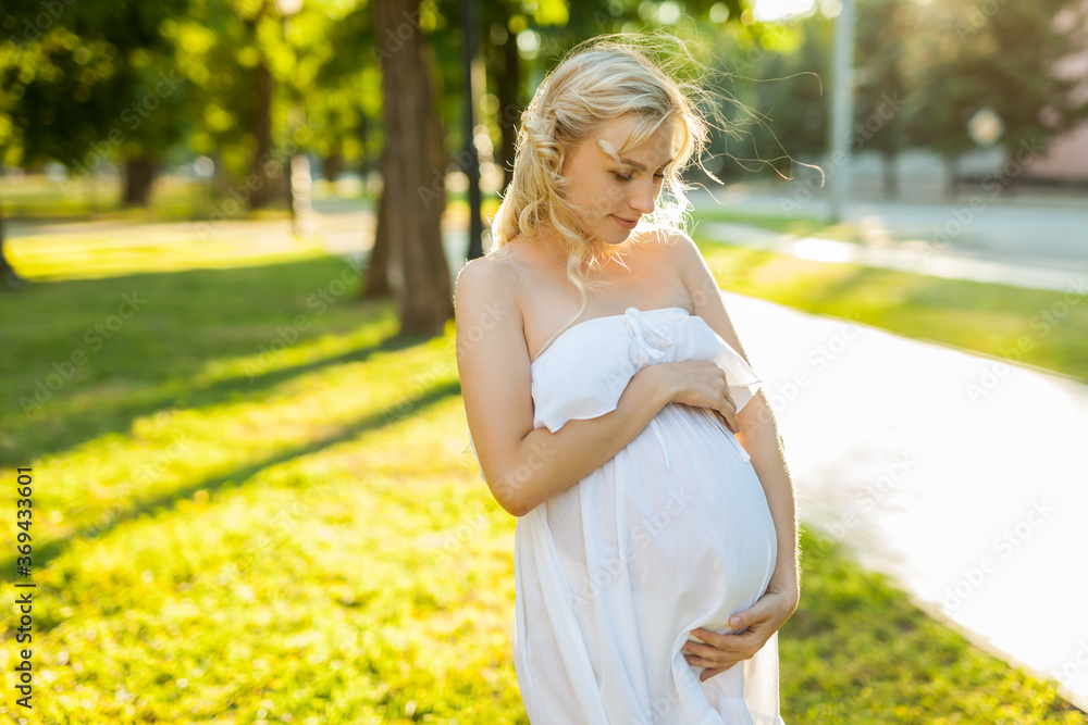 Portrait of a happy pregnant woman in a park