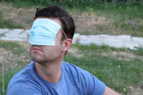 Man covering his vision with surgical mask 