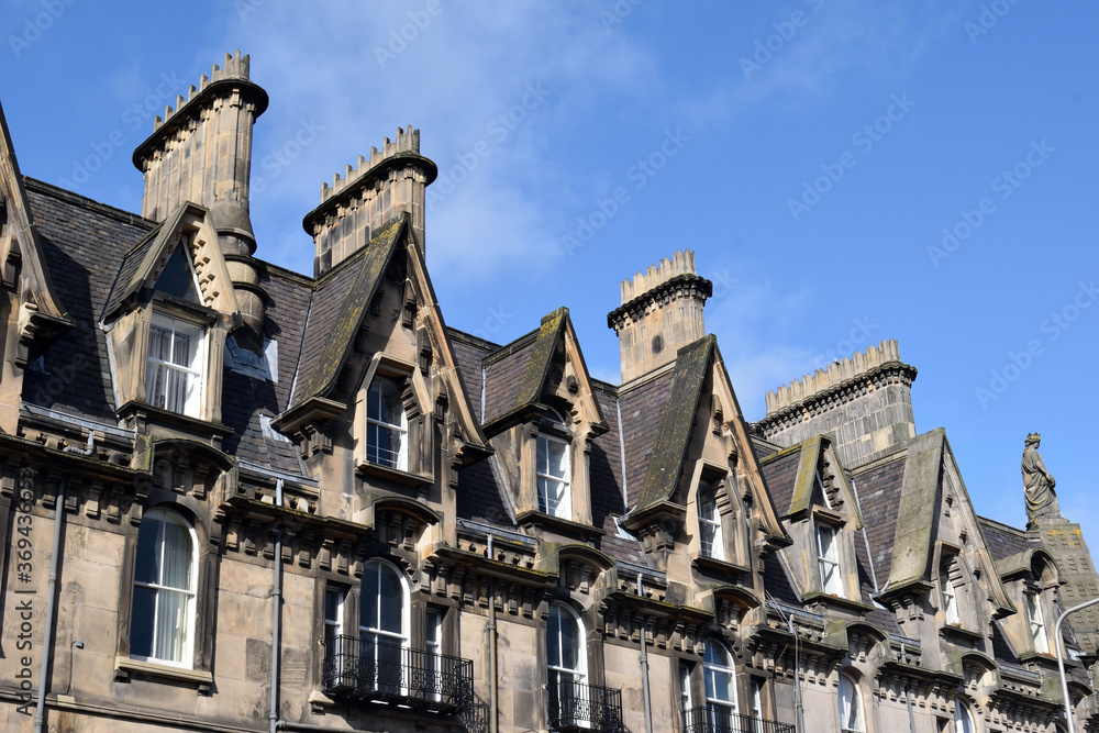 Chimneys & Dormer Windows on Roof of Victorian Houses against Blue Sky 