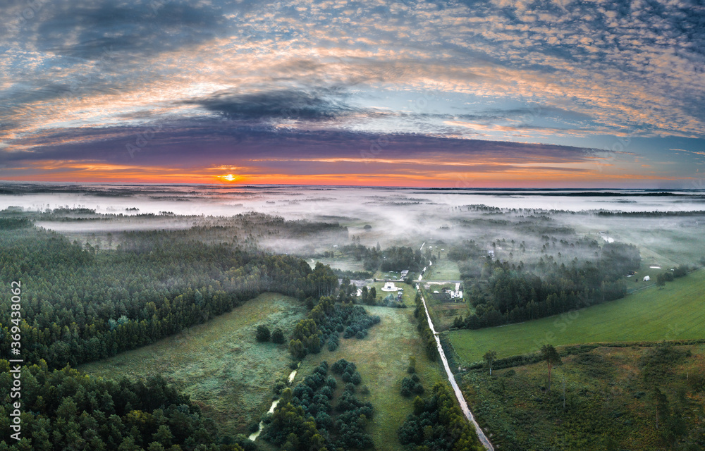 Aerial view of highway leading through a foggy countryside. Beautiful texture in the sky. Aerial landscape.