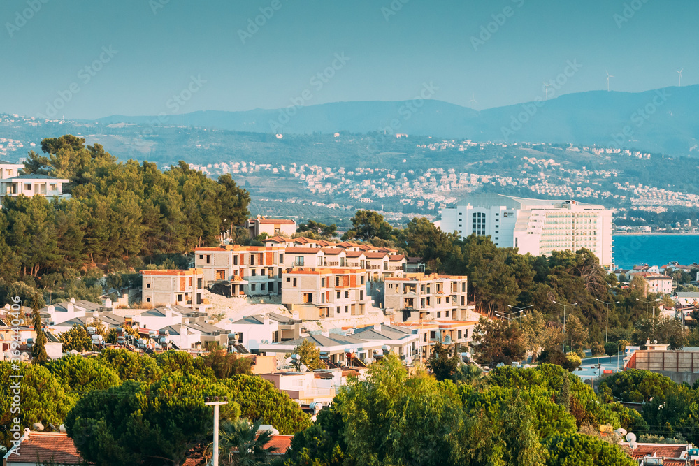 Obraz premium Kusadasi, Turkey. Beautiful Cityscape Of Turkish Town. White Residential Houses On Hillside. Real Estate Suburb In Summer Evening