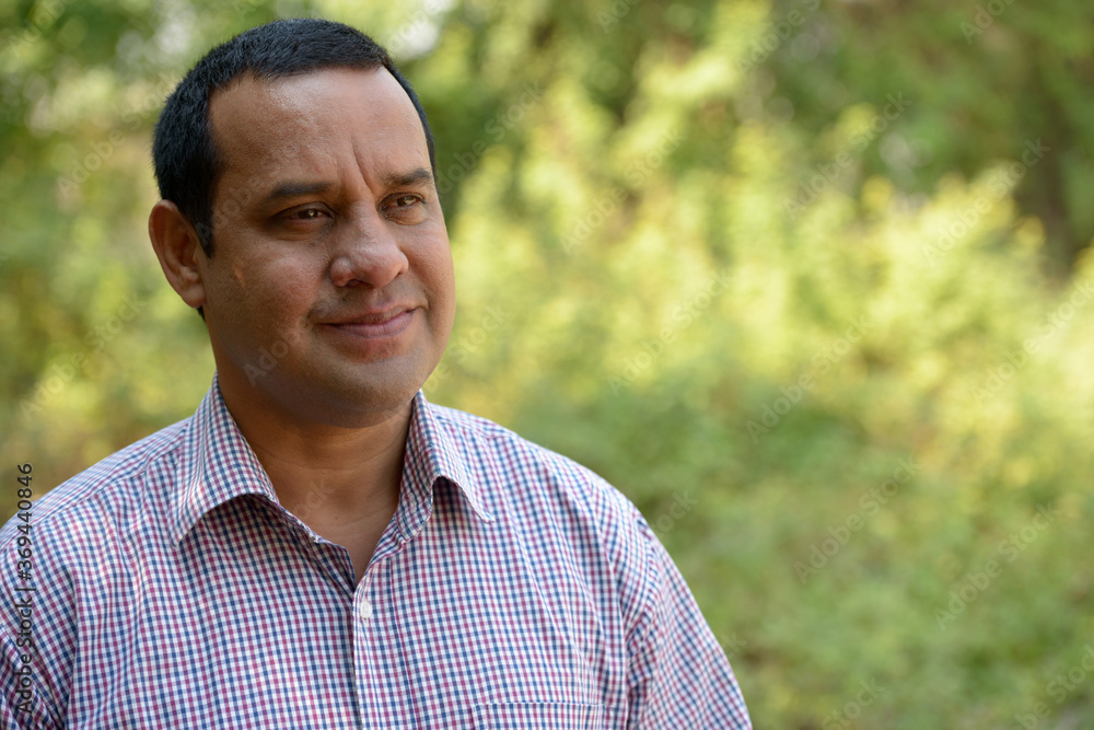 Portrait of overweight Indian businessman at the park outdoors Portrait of overweight Indian businessman at the park outdoors