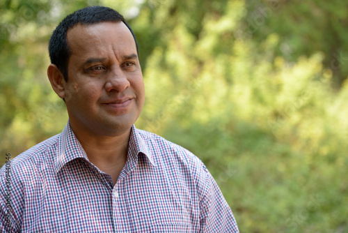 Portrait of overweight Indian businessman at the park outdoors
