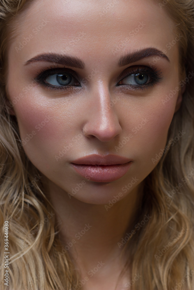 Sexy beauty face. Glamour portrait of beautiful woman model with fresh daily makeup. Fashion shiny highlighter on skin, sexy gloss lips make-up and perfect eyebrows. Natural beauty