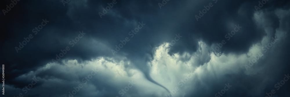 The typhoon is born, a tornado in a stormy dark sky with black clouds and a strong wind. Concept on the theme of weather, natural disasters, tornadoes, typhoons, tornadoes, thunderstorm. The typhoon is born, a tornado in a stormy dark sky with black clouds and a strong wind. Concept on the theme of weather, natural disasters, tornadoes, typhoons, tornadoes, thunderstorm.
