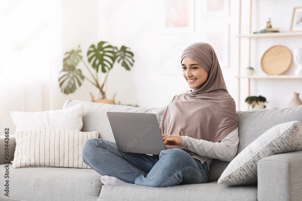 Remote Work For Muslim Women. Happy Arab Girl Using Laptop At Home Remote Work For Muslim Women. Happy Arab Girl Using Laptop At Home