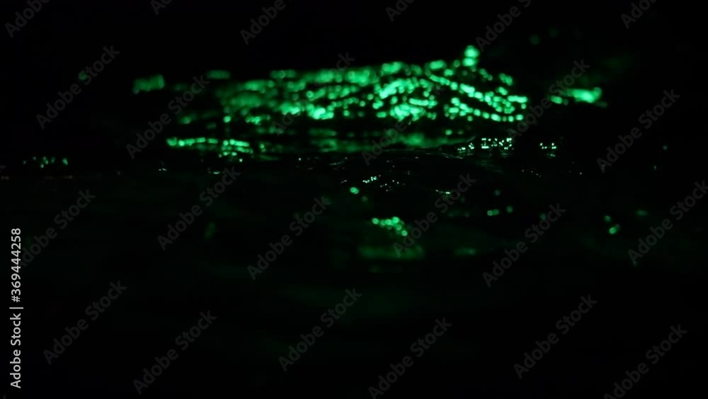 Waves and splashes in the dark water illuminated by blue light, in slow motion Waves and splashes in the dark water illuminated by blue light, in slow motion