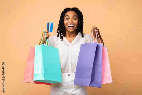 African Girl Holding Credit Card And Shopping Bags, Studio Shot