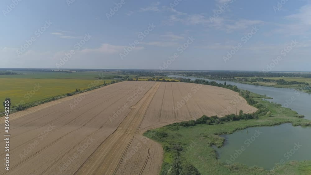 Picturesque wheat field along the river. Aerial view. Picturesque wheat field along the river. Aerial view.