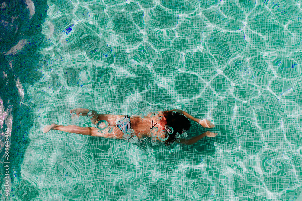 top view of young woman diving underwater in a pool. summer and fun lifestyle