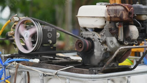 Flywheel turning on a stationary engine machine pump