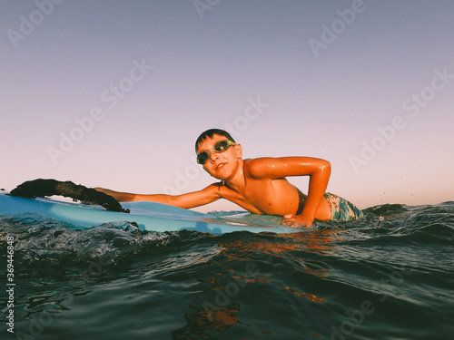 A young boy learning in body board outdoors in the shoreline in a sunny day of summer © Dellealpi