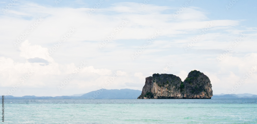 Blue ocean landscape in Krabi district with karst covered in vegetation jutting from the water 