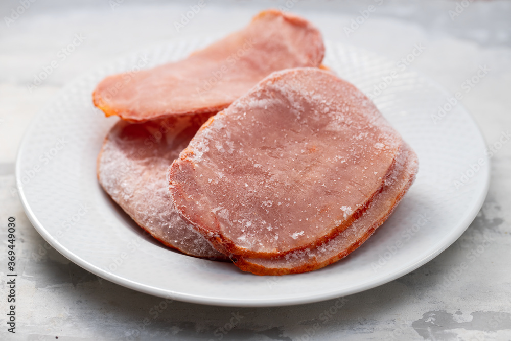 frozen pork on white plate on ceramic background frozen pork on white plate on ceramic background