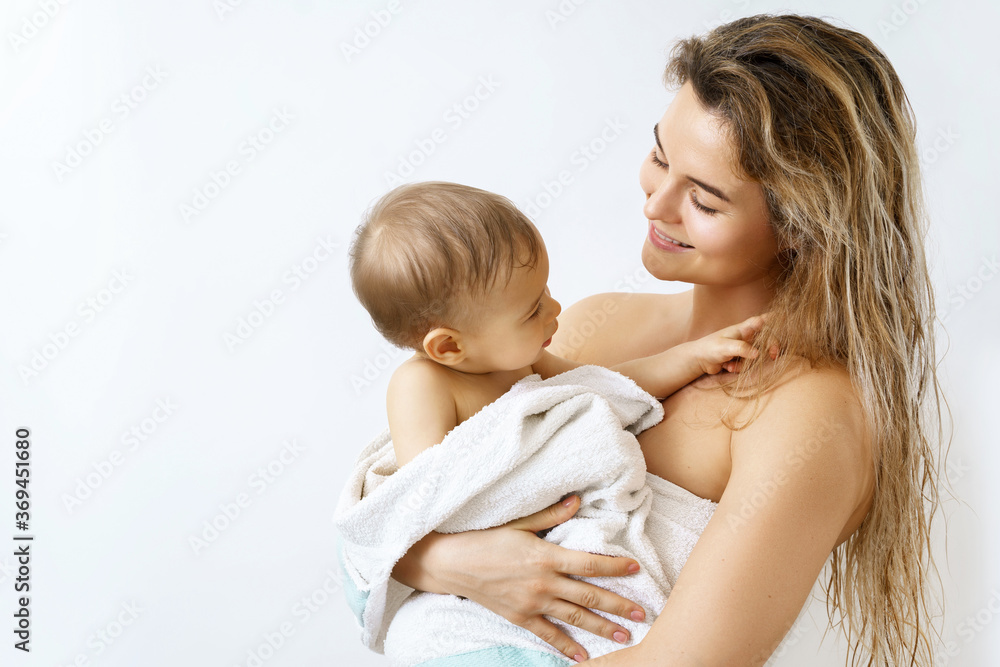 Young and happy mother and her cute little baby after bathing Young and happy mother and her cute little baby after bathing