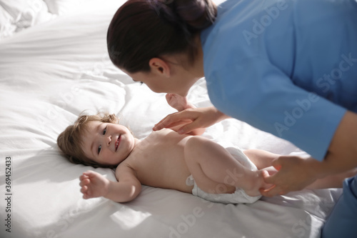 Orthopedist examining cute little baby on bed