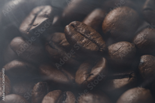 Close-up moody Macro shot of Freshly roasted delicious coffee beans with a light haze from roasting and soft light 