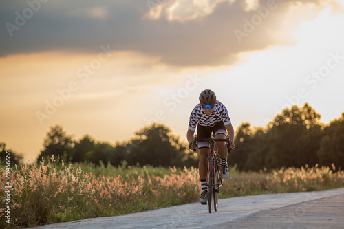 The man riding the bike fast with the sunset © sittipun