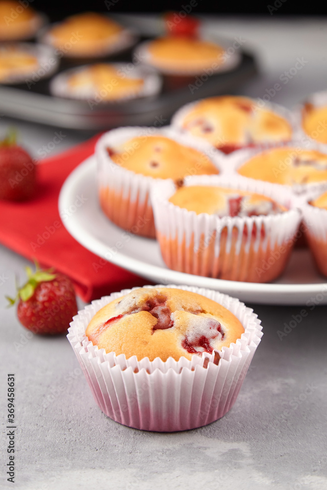 Strawberry muffins with fresh strawberries on grey concrete background Strawberry muffins with fresh strawberries on grey concrete background