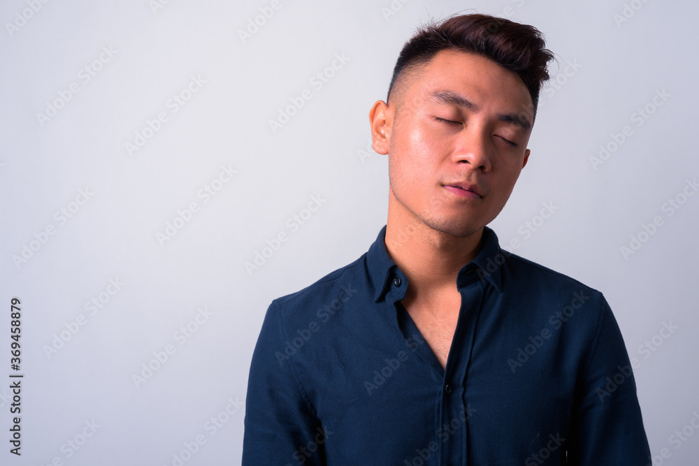 Face of young Asian businessman with eyes closed Face of young Asian businessman with eyes closed