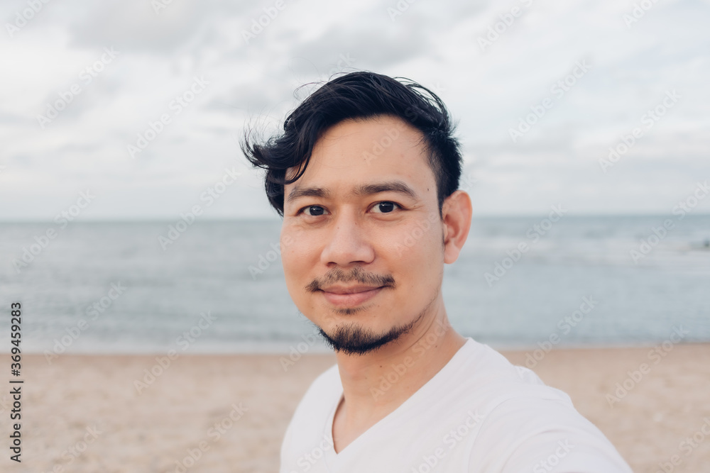 Happy Asian man selfie himself while walking on the beach. Happy Asian man selfie himself while walking on the beach.