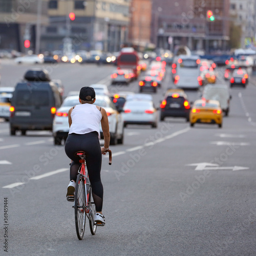 a woman rides a bicycle in the evening city