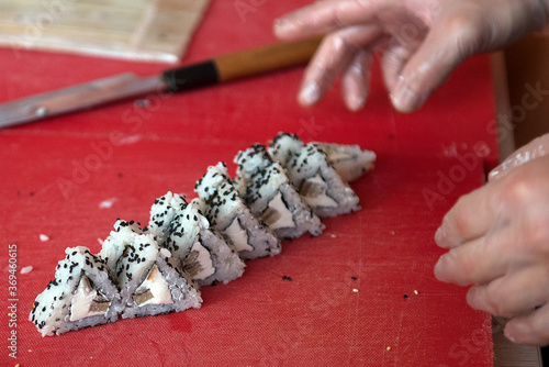 Pieces of sushi with triangular-shaped tomago olmet on a kitchen board, close-up. photo