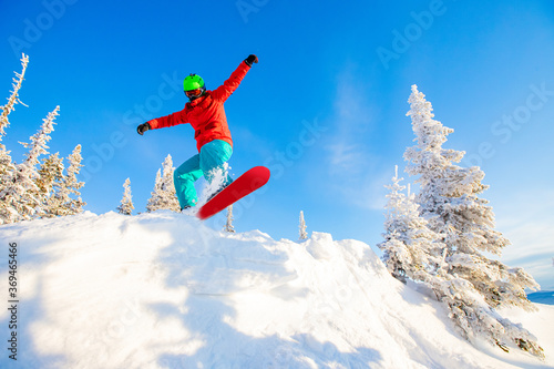 Snowboarder jumps in fresh snow forest. Freeride snowboarding in ski resort