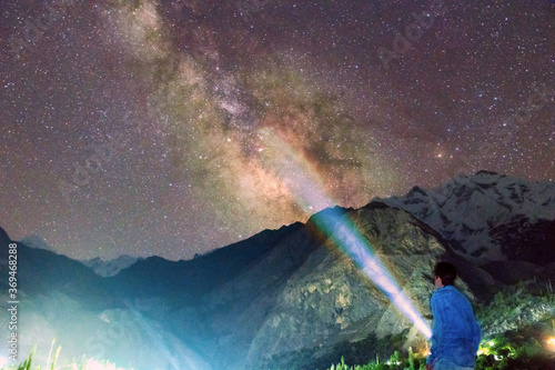mountains landscape with a boy lighting on the galaxy 