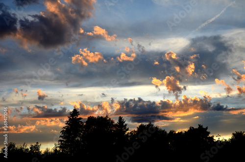 orange evening sky at sunset with torn clouds after crossing the cold front  photo