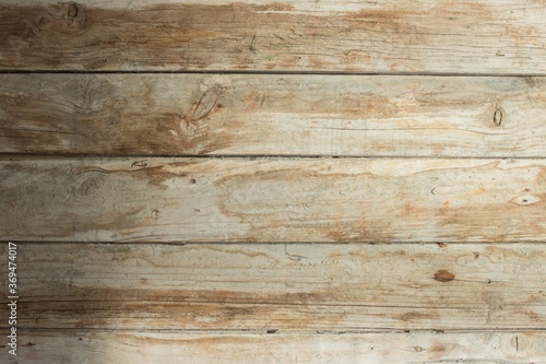 An old wooden plank with stains and a darker part rests inside a studio.