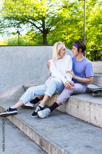 Happy and loving teenage couple in a skatepark