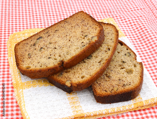 A fresh homemade loaf of banana walnut bread on clothtable photo