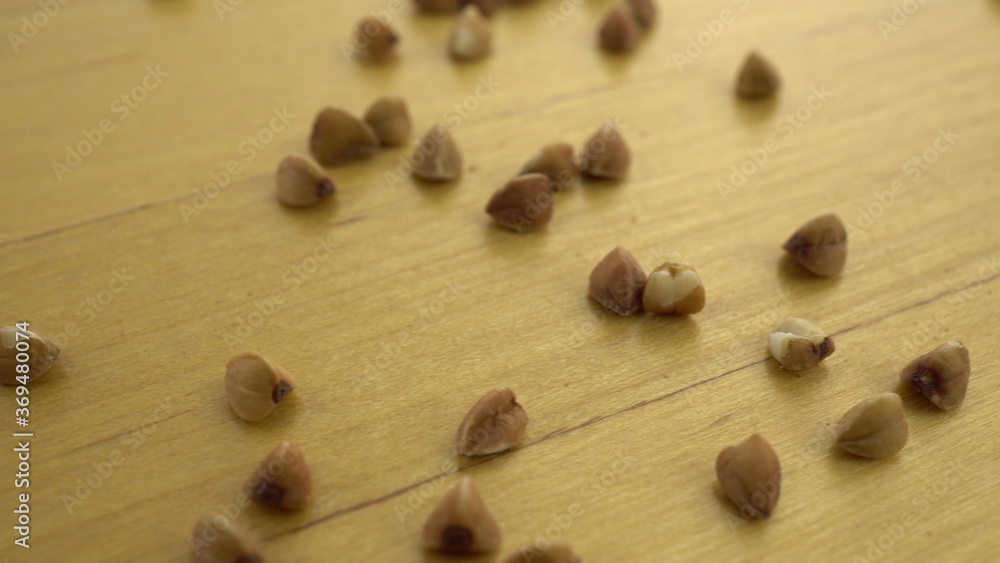 Buckwheat groats on a wooden surface. Macro shot of buckwheat. Buckwheat groats on a wooden surface. Macro shot of buckwheat.