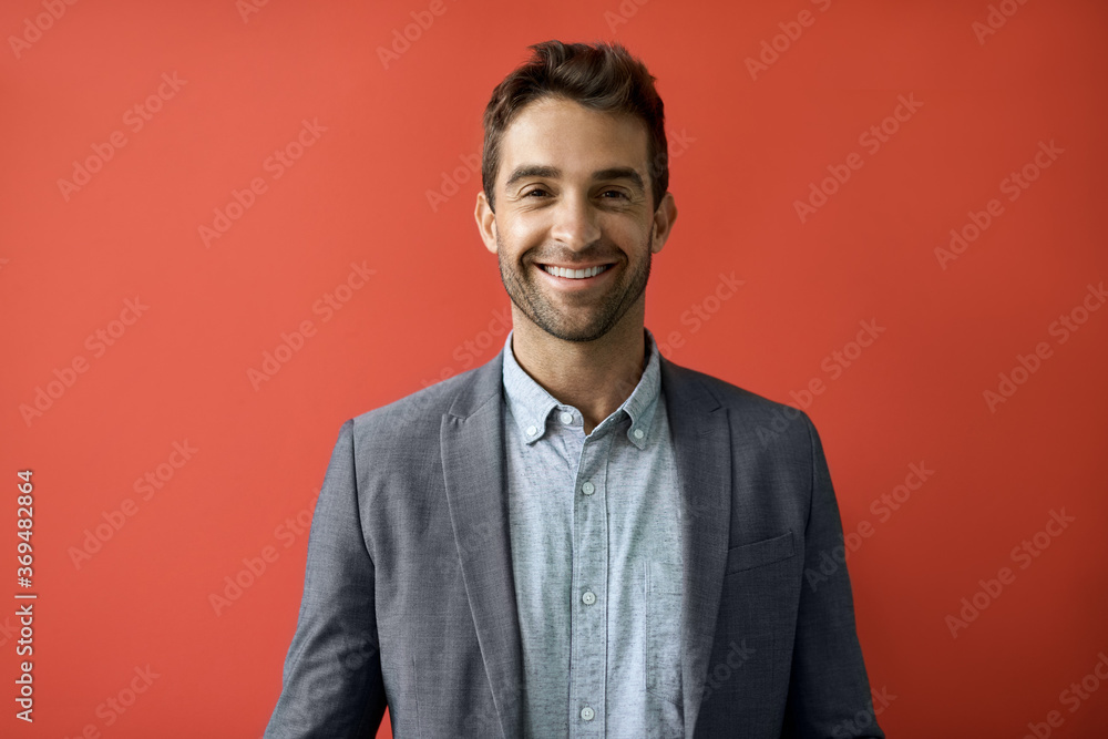 Smiling businessman standing in front of a red background Smiling businessman standing in front of a red background