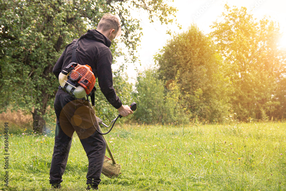  man mows cuts the grass in the garden of the village.