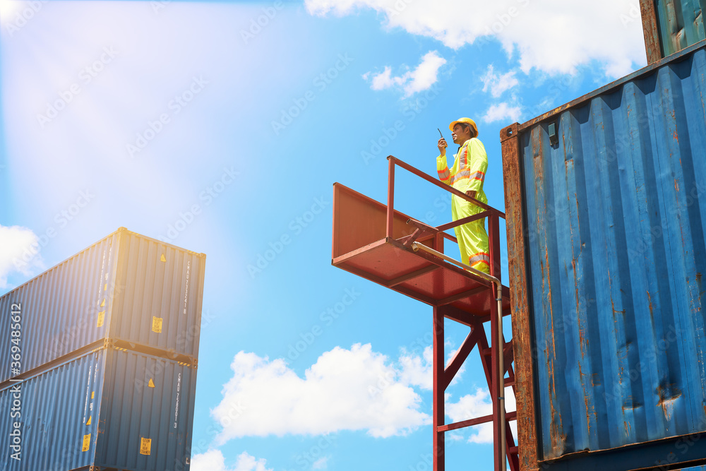 single engineer foreman stand on stair in cargo box container and order worker with walkie talkie single engineer foreman stand on stair in cargo box container and order worker with walkie talkie
